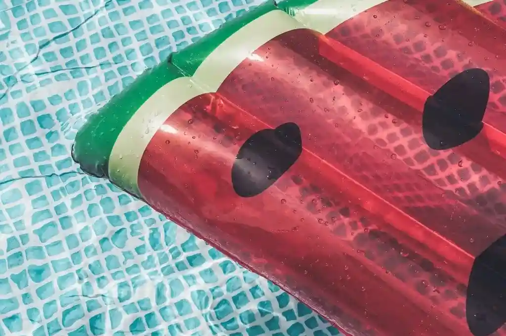 Folien Luftmatratze in Wassermelonen-Optik, schwimmt auf Poolwasser mit Fliesen