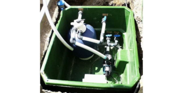 Bild mit grüner Technikbox in den Boden eingelassen, mit Sandfilter, Pumpe und Rohren